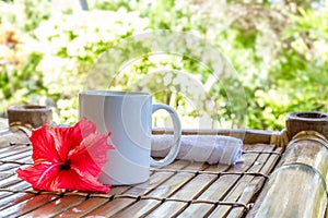 Mug with cappuchino on bamboo table, coffee cup in the mor