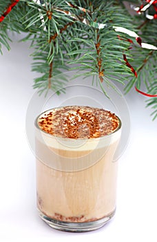 Mug of capuccino under fir-tree branch