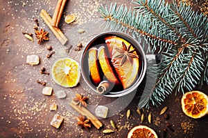 Mug of christmas mulled wine or gluhwein with spices and orange slices on rustic table top view. Traditional drink on winter.