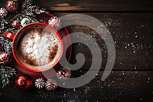 Mug of cocoa with marshmallow placed near fir twigs on wood background in christmas time