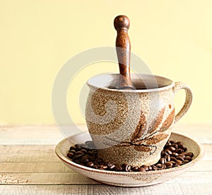 Mug with coffe and coffe beans on saucer. Beautiful coffee mug
