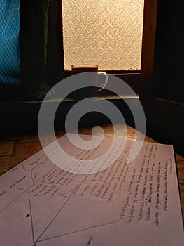 A mug of coffe with paper of assigment