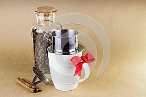 Mug with coffee dripper, and a glass jar of coffee beans.