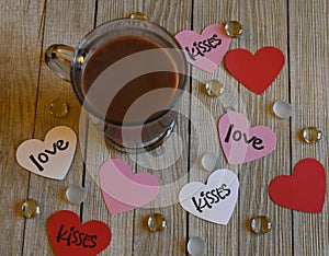 Mug of coffee with heart shaped sentiments on wood background