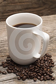 Mug of Coffee Resting on Roasted Coffee Beans