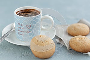 A mug of coffee on a saucer with cookies