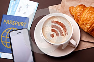 Mug of coffee with WiFi sign on the foam. Free access point to the Internet WiFi. I like coffee break with croissant