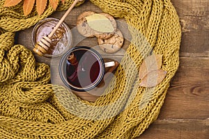 Mug or Cup of Hot Berry Tea With Yellow Warm Knitted Scarf Autumn Maple Leaves Wooden Background Top View Flat Lay Autumn Cold sea