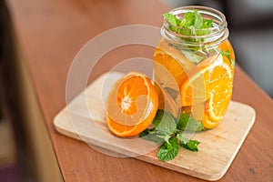 Mug delicious refreshing drink of orange fruit , infused water photo