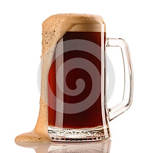 Mug of frosty dark beer with foam isolated on a white background