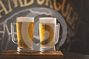 Mug full of chopp, with dark chopp on a rustic table.