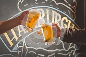 Mug full of chopp, with dark chopp on a rustic table.