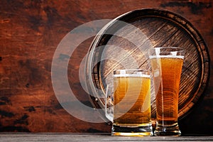 Mug and glass of light lager beer and wooden barrel