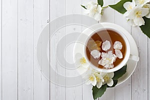 Mug of herbal tea with petals of Jasmine flowers on a light background. Copy space