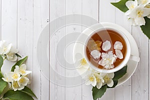 Mug of herbal tea with petals of Jasmine flowers on a light background.