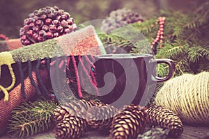 Mug of hot beverage on a rustic wooden table. Still life of cones, twine, packthread, fir branches. Preparing for Christmas.