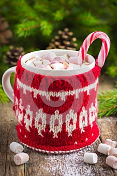 Mug with hot chocolate, murshmallow and candy cane, wrapped in a