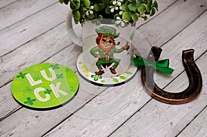A mug with the image of a leprechaun and a quatrefoil, a horseshoe for happiness and good luck. St.Patrick \'s Day.