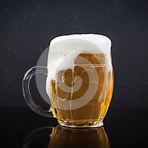 Mug of light beer on dark background. Craft unfiltered beer