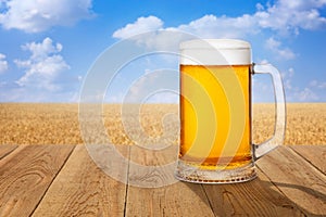 Mug of beer against wheat field