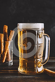 Mug of light beer with foam, croutons on a dark background, refreshing alcoholic drink