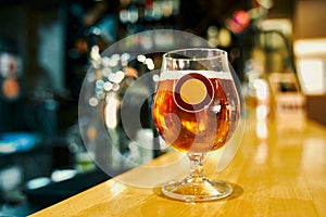 Mug of tasty cold beer standing on table in pub