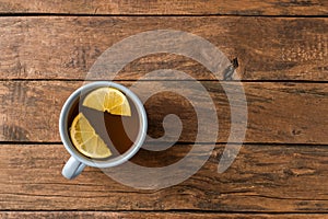 Mug of tea with lemon on white wooden background with copyspace.