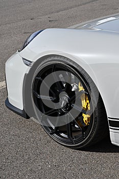 Mugello Circuit, Italy - 23 September 2021: detail of an alloy wheel rim with yellow brake caliper of a Porsche 911 in the paddock
