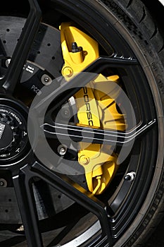 Mugello Circuit, Italy - 23 September 2021: detail of an alloy wheel rim with yellow brake caliper of a Porsche 911 in the paddock