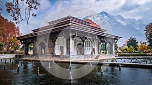 Mughal Heritage Building with snoe covered Zabarwan Mountains in the background during Autumn in Shalimar Bagh Mughal Garden of