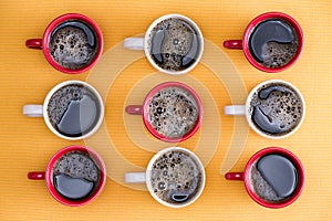 Mugs of black coffee in alternating colors