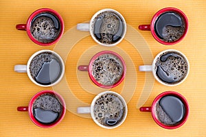 Mugs of black coffee in alternating colors photo