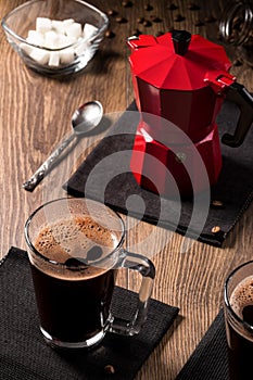 Mugs of coffee on black napkins near the coffee maker