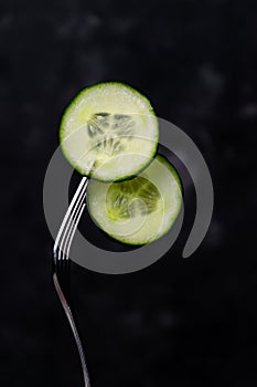 mugs of green cucumber on a fork