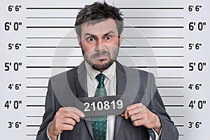 Mugshot of man in suit at police station