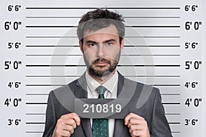 Mugshot of man in suit at police station