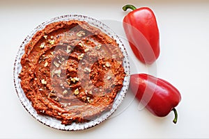 Muhammara, healthy walnut and roasted red bell pepper dip in a ceramic white plate