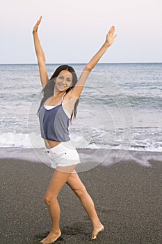 Young woman on the beach in very positive and happy attitude photo