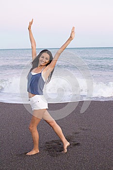 Young woman on the beach in very positive and happy attitude photo