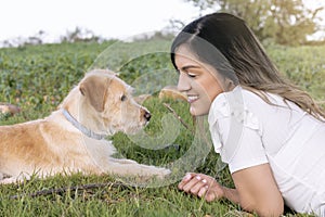 mujer joven tumbada en el campo con su perro, photo