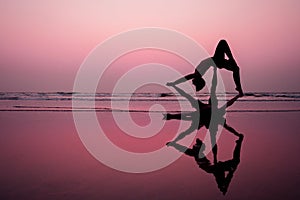 Muladhara swadhisthana manipula tantra yoga on the beach man and woman meditates sitting on the sand by the sea at photo
