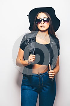 Mulatto girl wearing sunglasses and black hat over a white background.