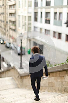 Mulatto guy walking down steps with newspaper.