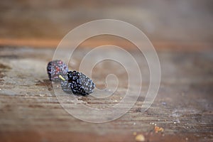 Mulberry berries on wooden table close up.