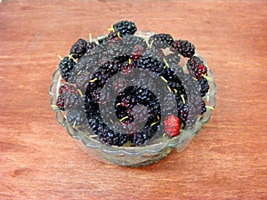 Mulberry fruit color derives from anthocyanins, mulberry in crystal plat on wooden table photo