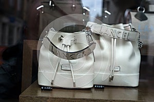 Closeup of white Lancel Hand bags in a luxury fashion store showroom