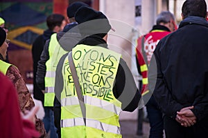 people protesting with yellow vest with text against the government reforms