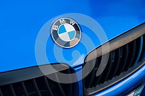 BMW logo on blue car front parked in the street