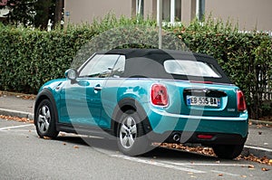 Blue mini cooper convertible parked in the street