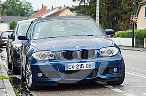 Front view of blue convertible BMW parked in the street